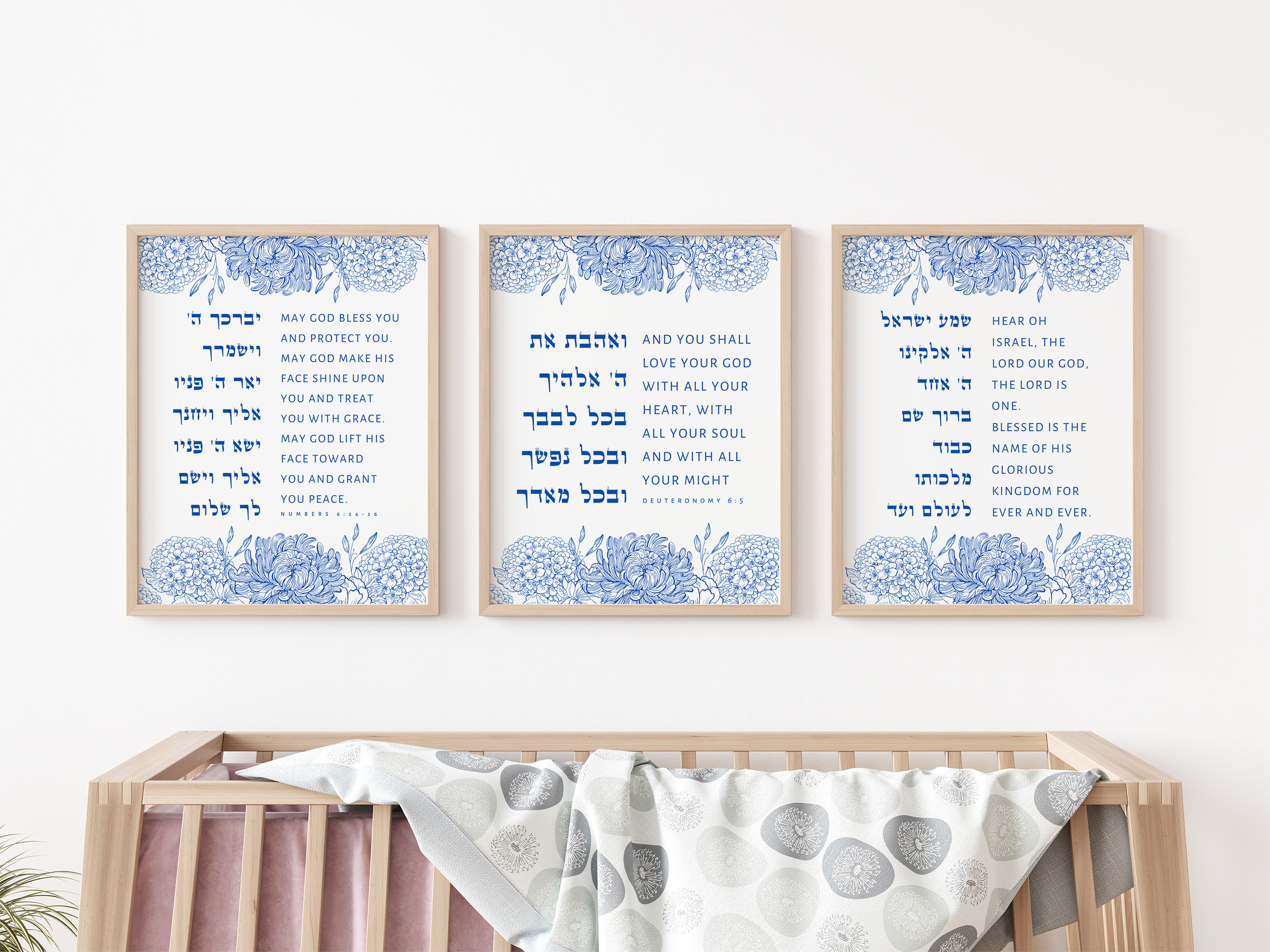 Three framed prints with text above a crib in a nursery setting