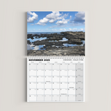 Calendar for November 2023 with a scenic view of rocks and water on a white background