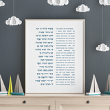 A framed Hebrew and English Bible print of psalm 23 displayed on a light wood dresser against a dark gray wall decorated with white paper clouds.